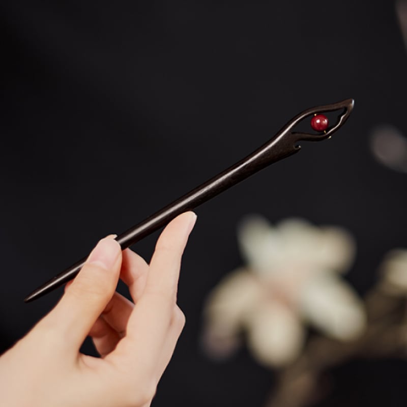 Styled with traditional hair arrangement, rich red finish visible at ends
