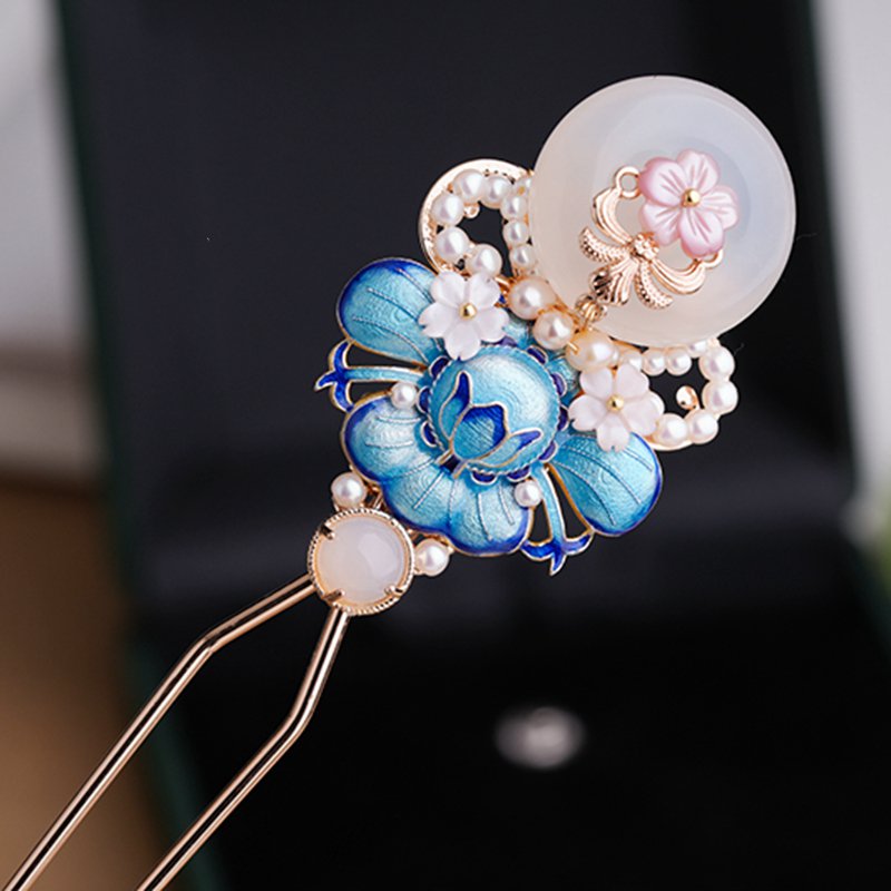 Detail shot of carved floral motif and polished stick nearing a styled updo