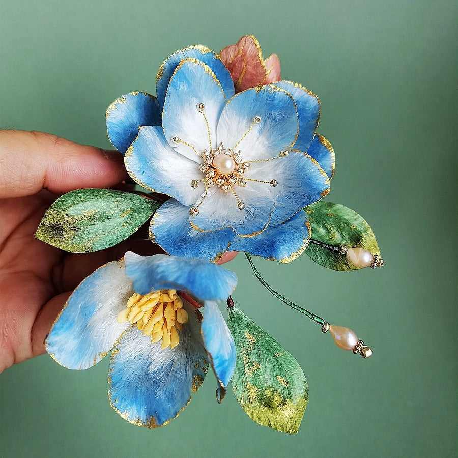 Back view showing comb teeth securing hair while the floral ornament sits above a bun.