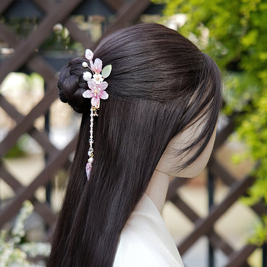 Ivory-toned floral barrette securing a half-up hairstyle at crown