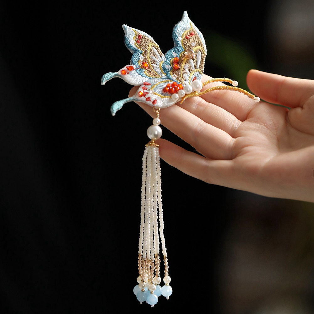 tassel butterfly brooch pin on a Qipao displayed on fabric