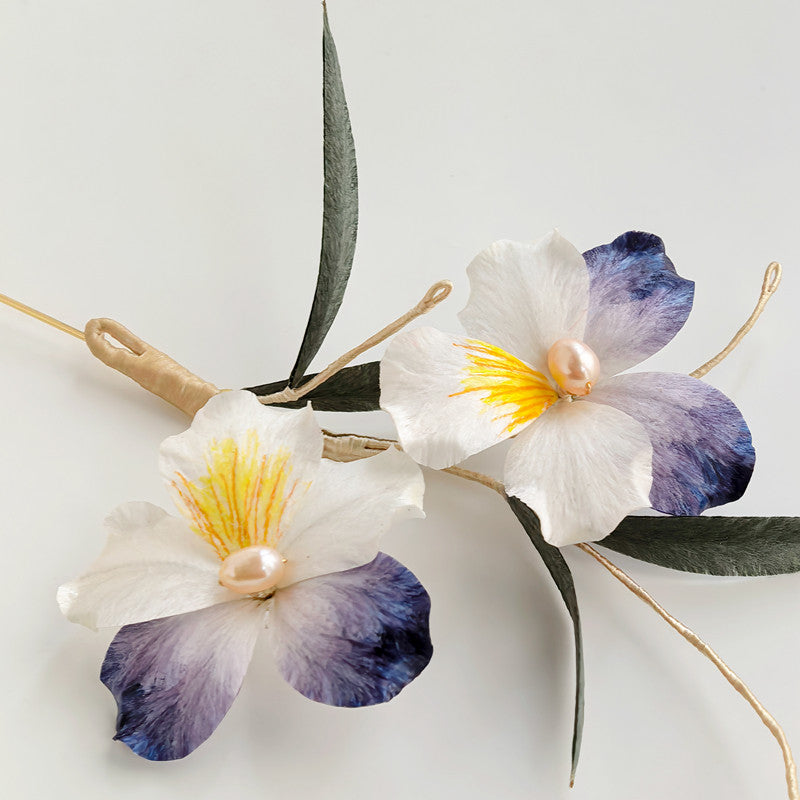 purple double-flower brooch pin on a blazer displayed on fabric