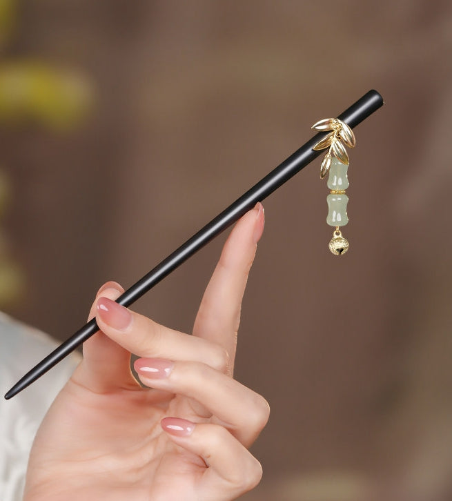 Angled view of stick resting beside fabric, highlighting polished wood and tassel