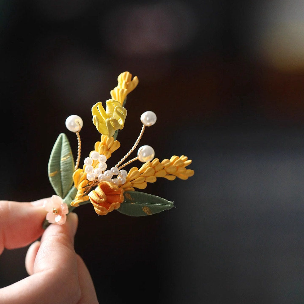 Angled handheld detail reveals textured petals, warm metal tones, beadwork