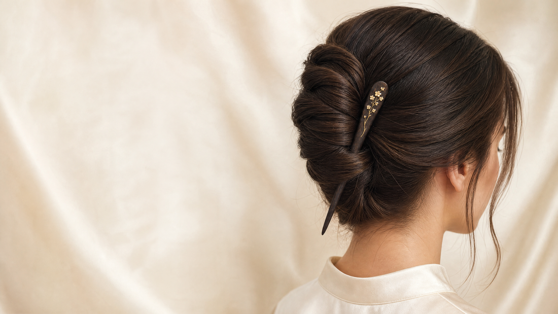 A dark wood floral hair stick securing an elegant French twist.