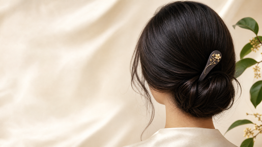 A single floral hairpin placed beside a low bun with open space around the accessory.
