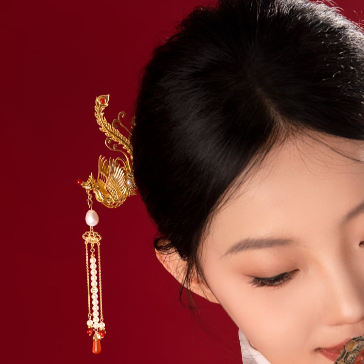 Close-up of layered floral motif and metalwork resting beside silk ribbon