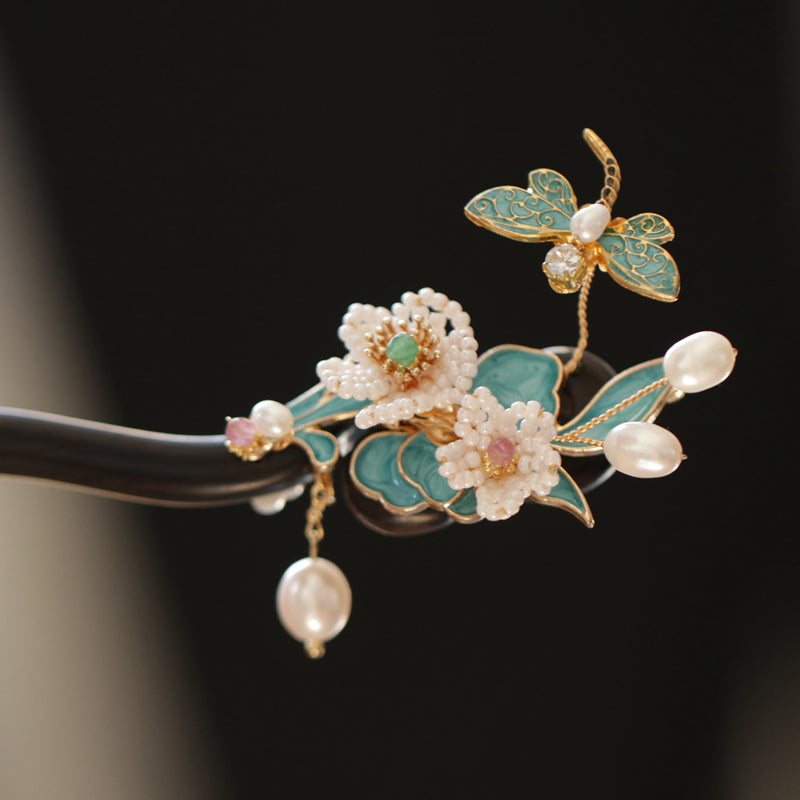 Warm brown wood stick with carved flower motif tucked into low bun