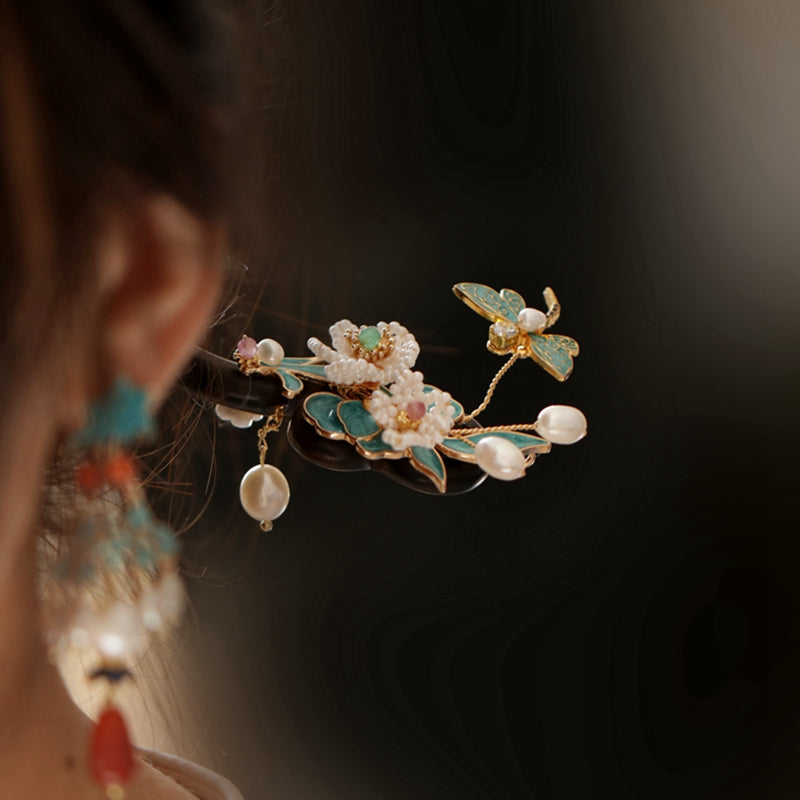 Two wood-style pins crossed over an elegant updo as subtle accents