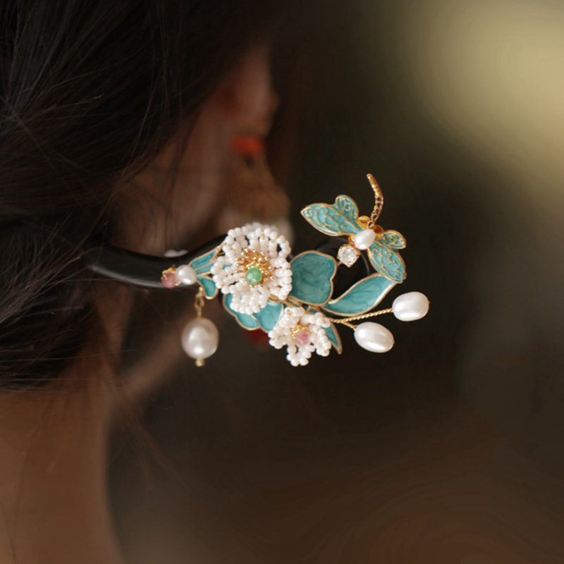Close-up of delicate carved floral detail on smooth dark wood hair stick