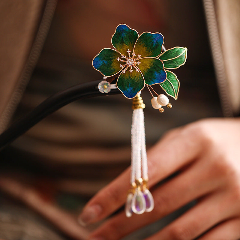Close-up of gold-finish floral pin head resting atop a low bun