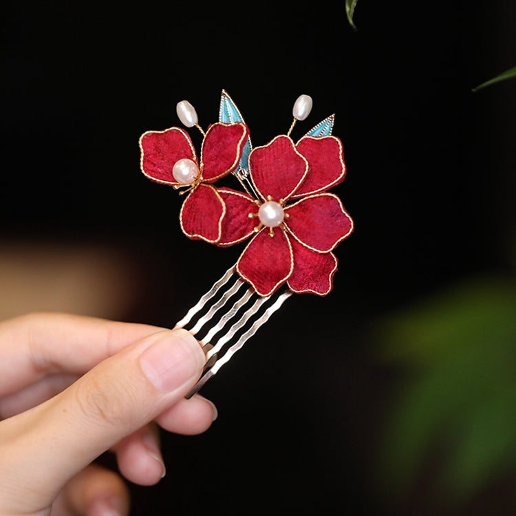 Dark wood-look hair stick topped with painted pink flower, inserted into low bun