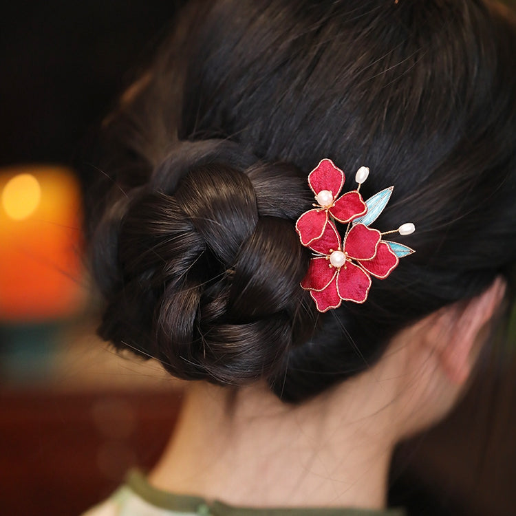 Side view of floral-tipped stick holding twisted half-up hairstyle on model