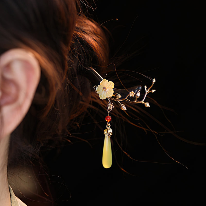 Close-up of carved blossom detail on warm brown hair stick