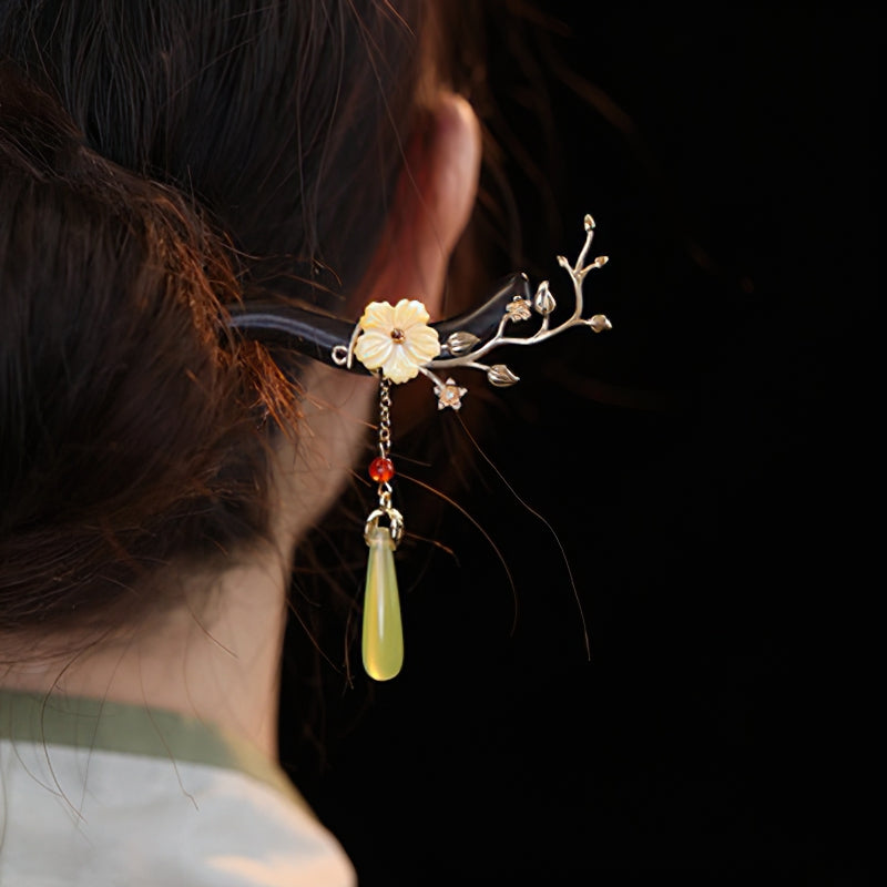 Two hair sticks crossed to secure a messy bun at nape