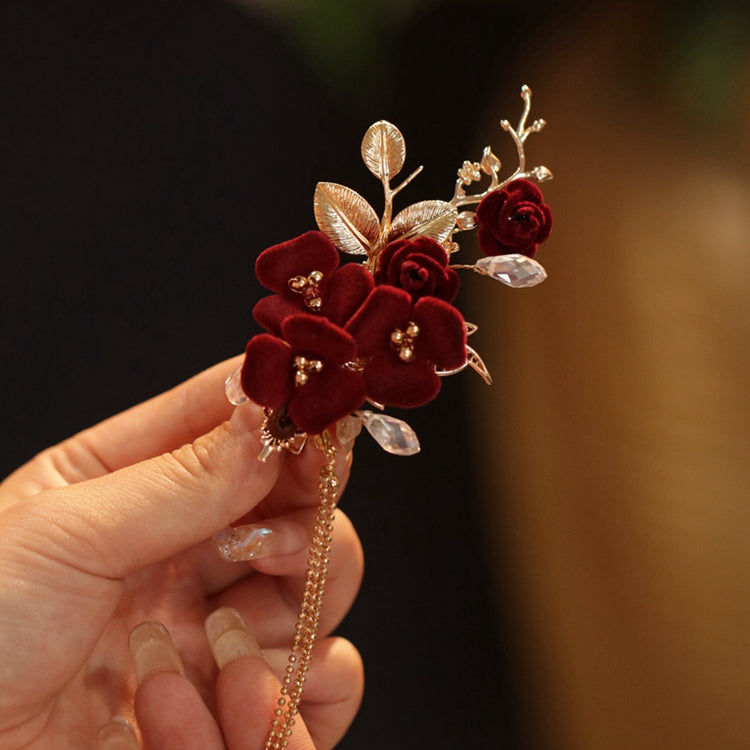 Close-up of a red camellia blossom mounted on a slender stick near a bun