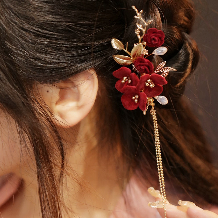 Side view showing deep crimson flower accent securing a half-up hairstyle