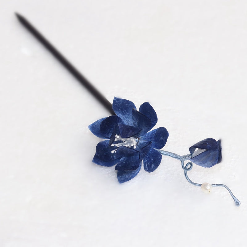 Delicate lotus petal carving near tapered end held through styled bun