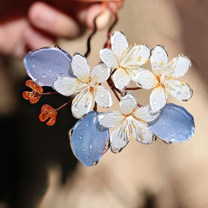 Warm antique-gold hairpin with layered floral motif, tucked into a low bun