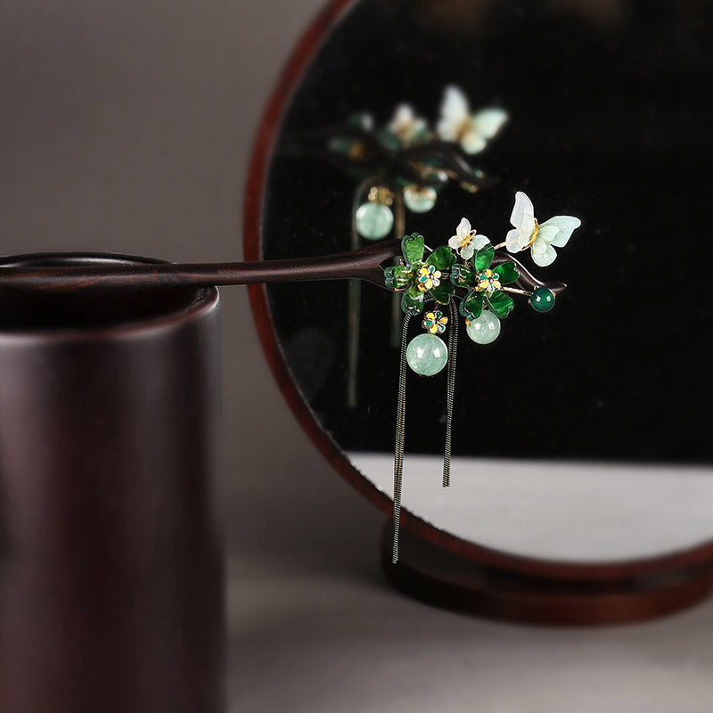 Black wood-look hair stick with long black tassel inserted in a bun