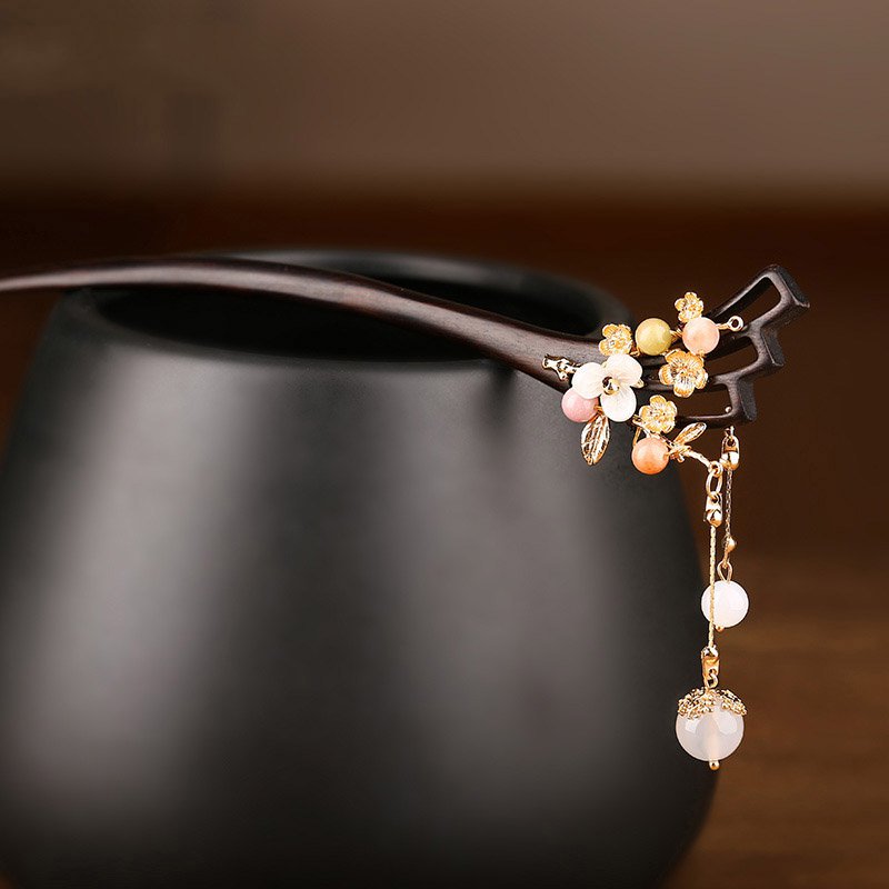 Hairpin angled across low bun with tassel draping down shoulder