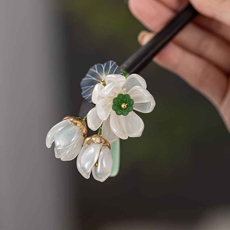 Hair stick inserted through a low bun showing carved floral detail