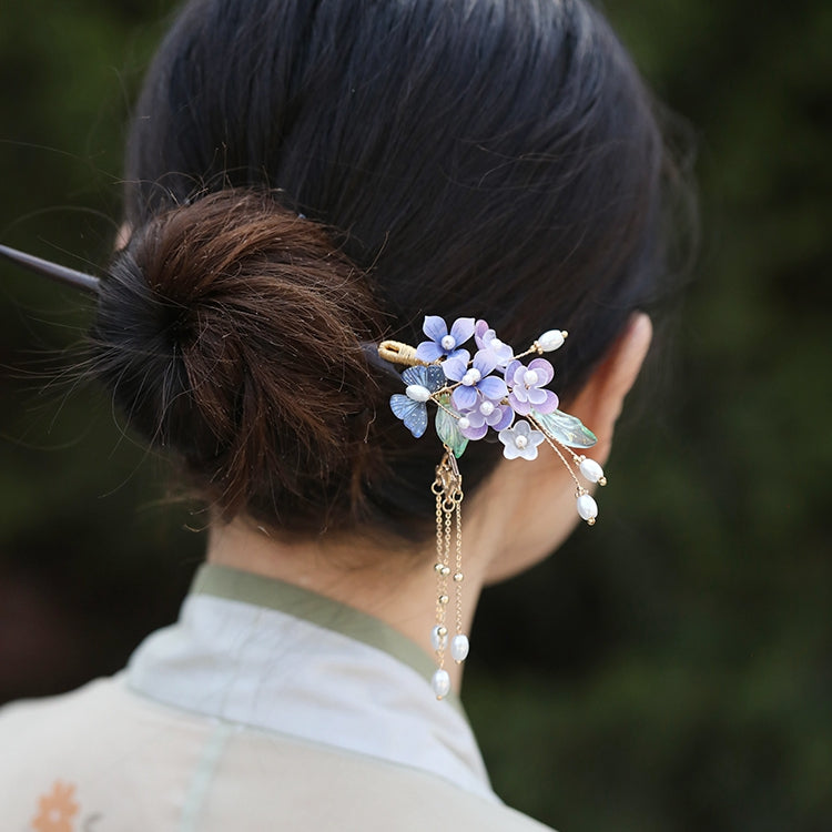 Close-up of delicate purple flowers and subtle metallic accents on top of stick