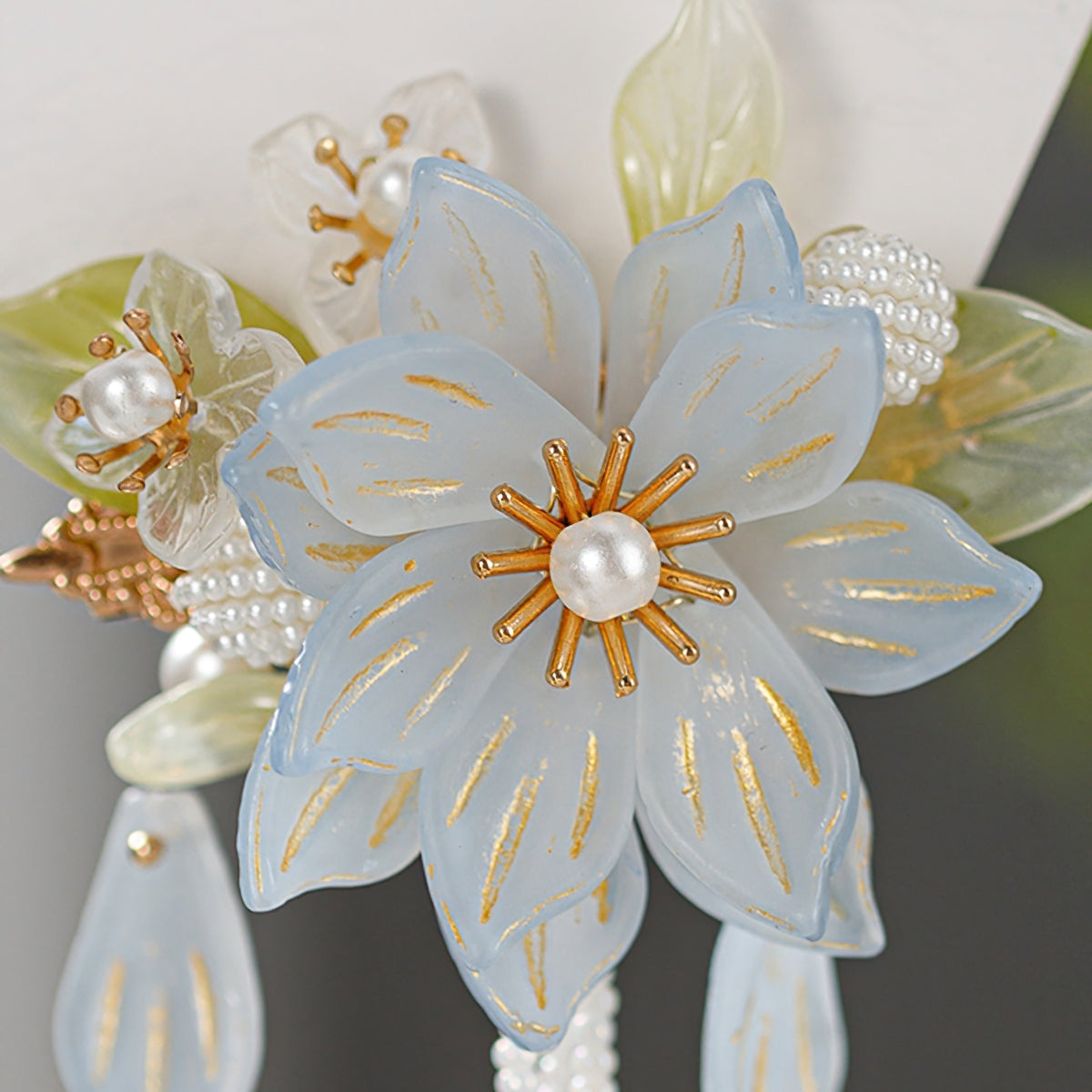 Small floral pin with slender warm-toned stem tucked into a classic bun effortlessly