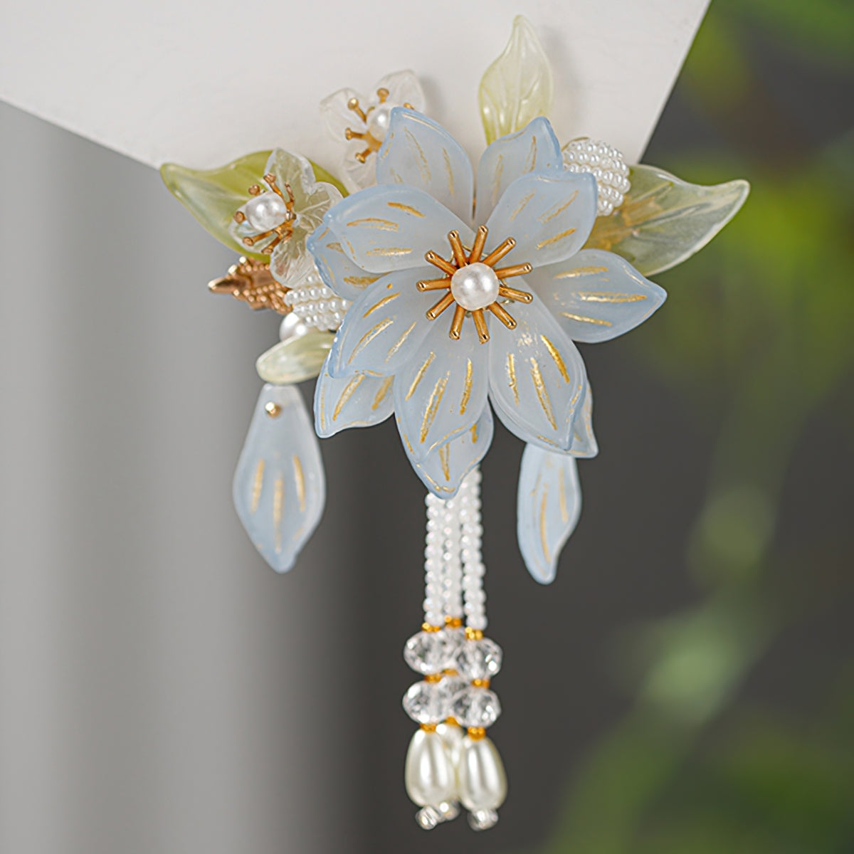 Soft blush and cream floral cluster clipped above a low bun, delicate finishing touch