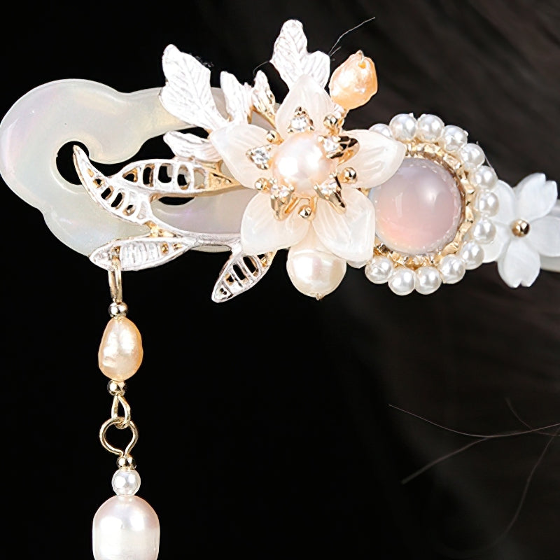 Two hair sticks crossed over an elegant soft bun on neutral background