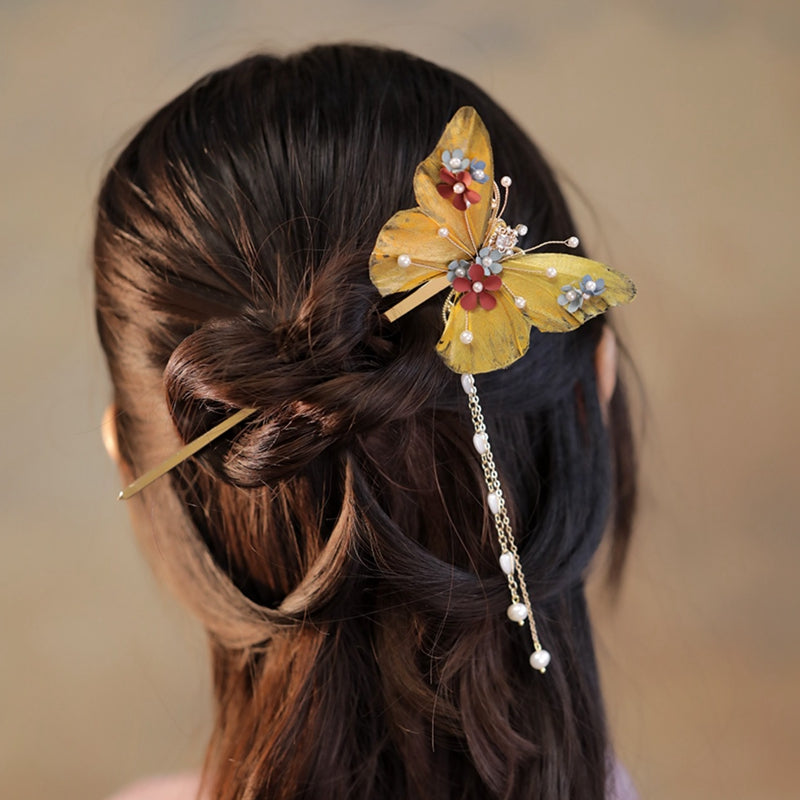 Detail shot of pin inserted through a loose updo, warm metallic color visible