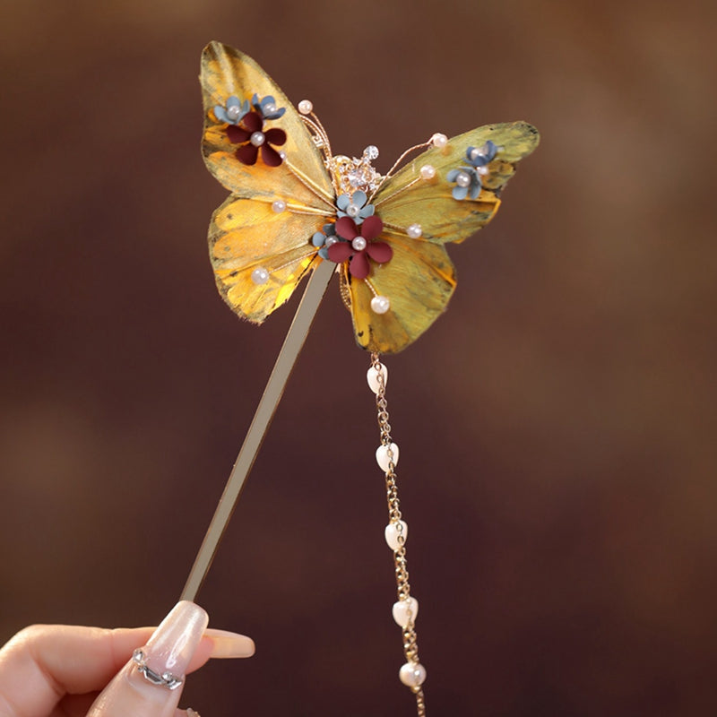 Close-up of gold-tone butterfly motif resting on a styled low bun