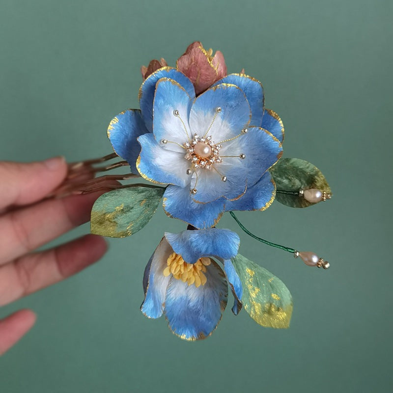 Three-dimensional peony-style bloom resting on a comb base with subtle gold accent.