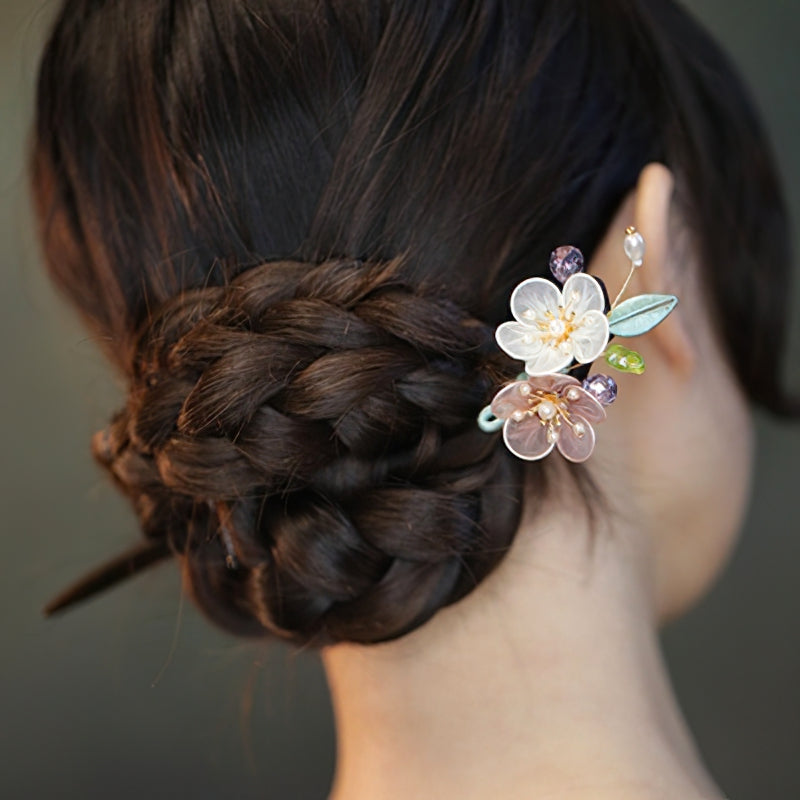 Close-up of carved floral detail on the dark hair stick, textured finish