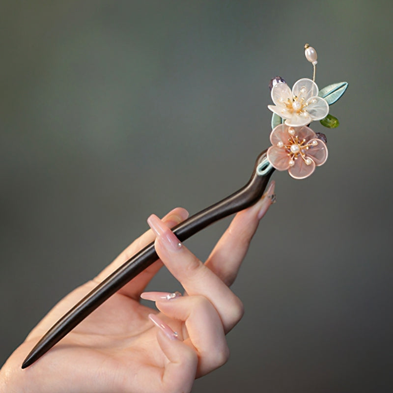Dark sandalwood-look hair stick with carved floral tip holding a low bun