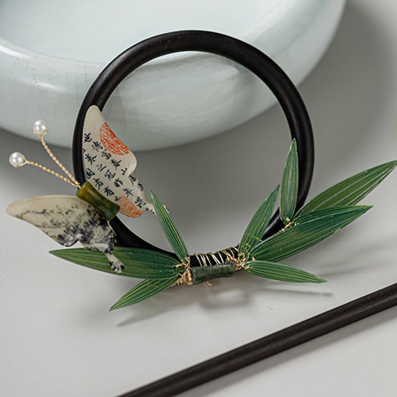 Hair stick positioned beside a low bun, ready for styling