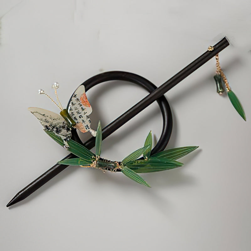 Dark wood-toned hair stick resting diagonally on pale fabric surface