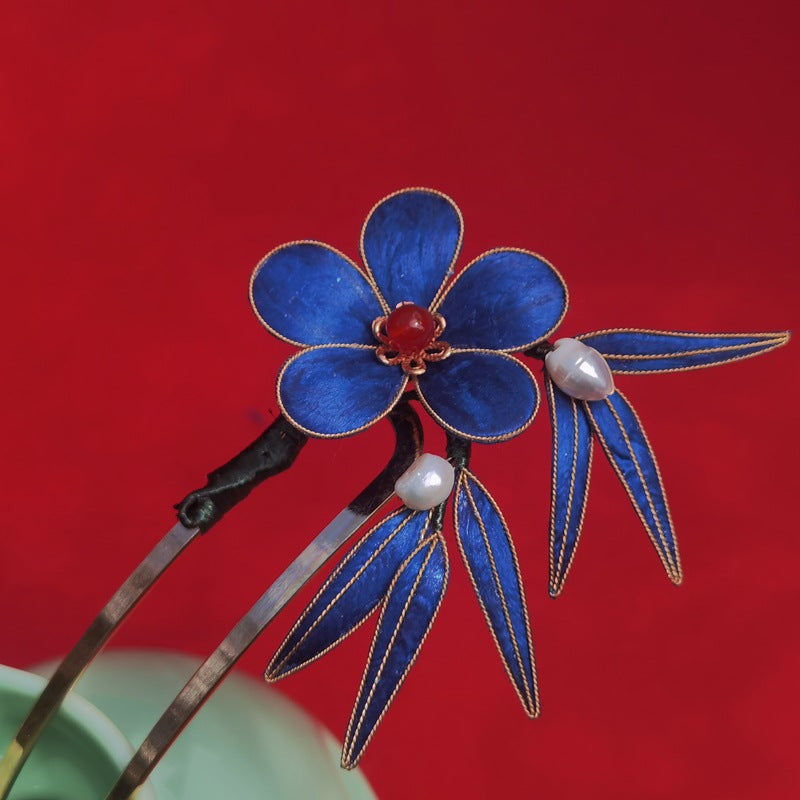 Slim hair pin topped with a soft blue fabric flower, shown in side profile