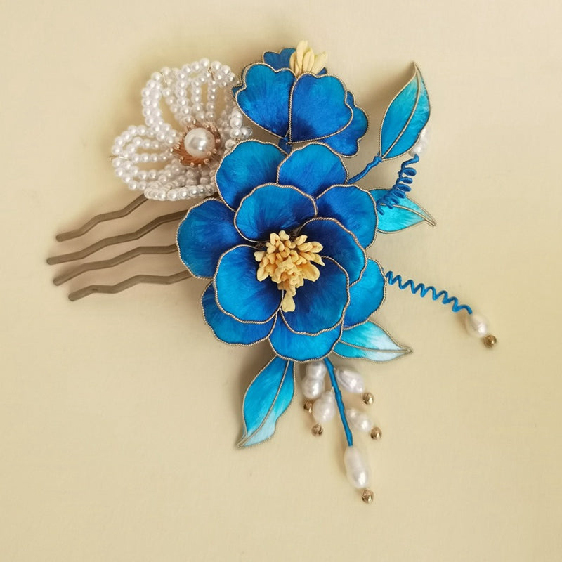 Hair stick securing a low bun, blossom visible above the gathered hair