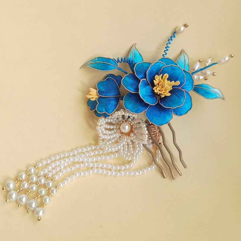 Detail of sculpted blue blossom attached to a dark hair stick, top view