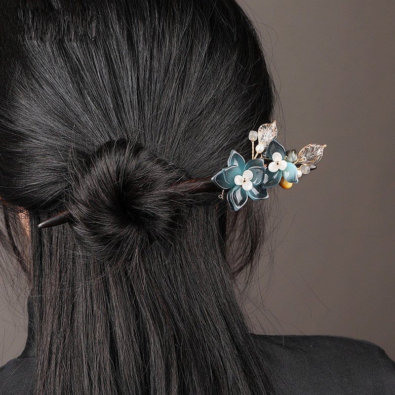 Hair stick threaded through a soft low bun holding hair securely in place