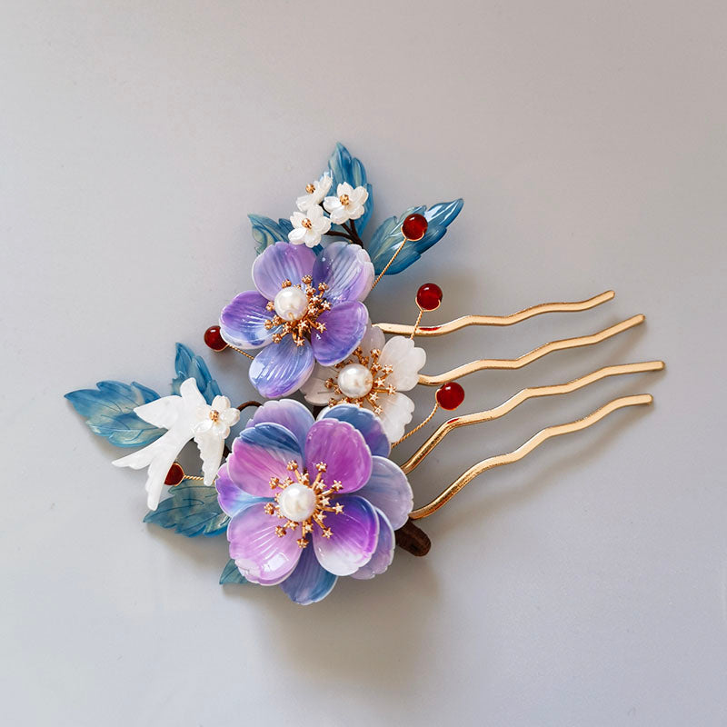 Soft blue petal ornament resting above a low bun on a model