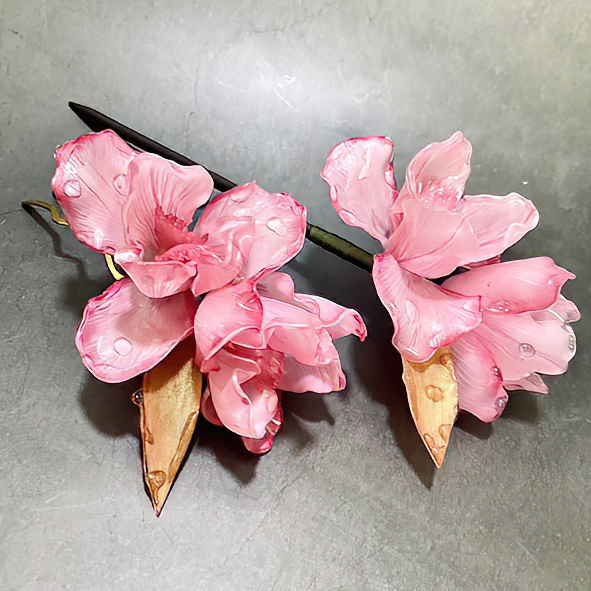 Close-up of painted iris blossom on tapered stick, shown on wooden surface