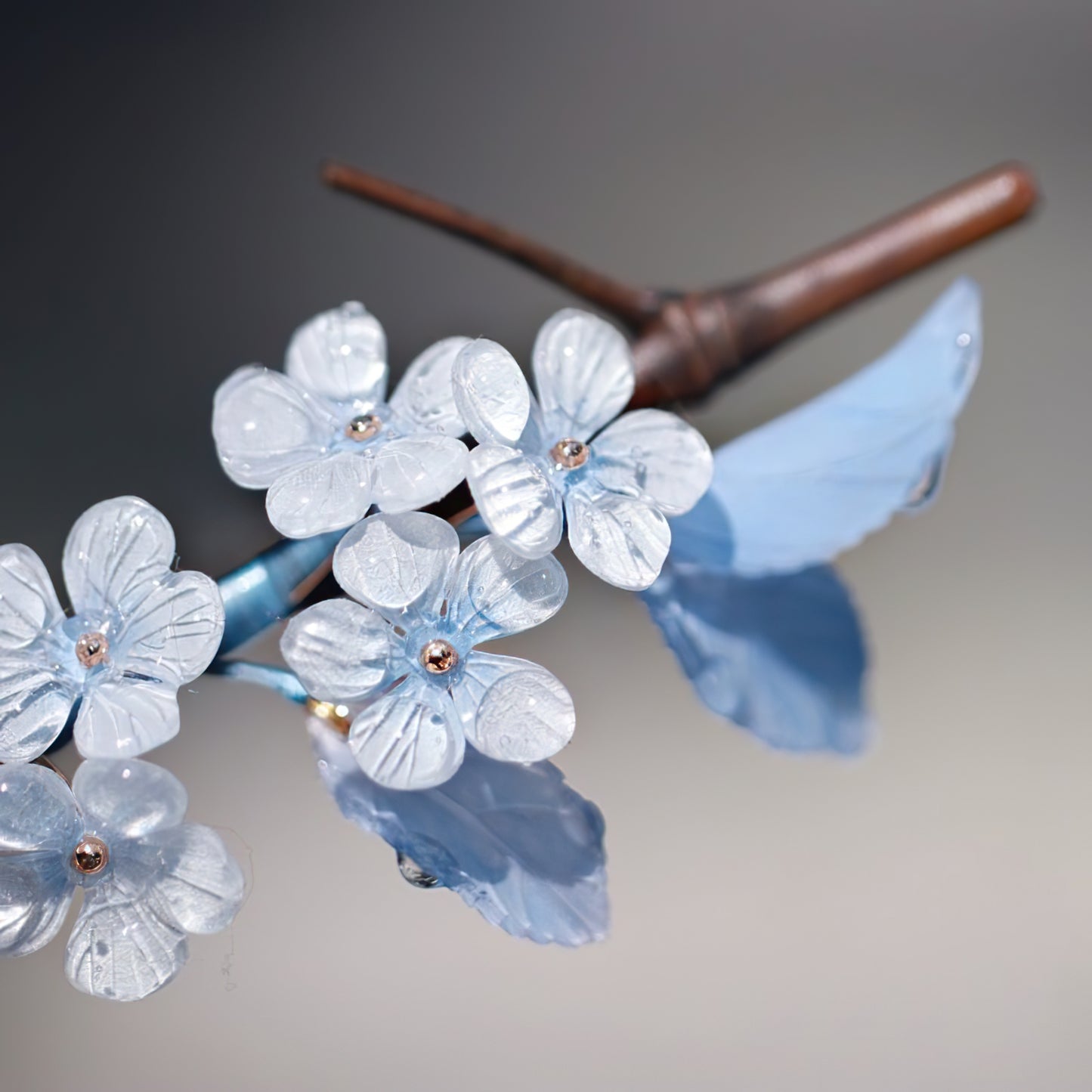 Close-up of blue flower motif on slender stick placed in a bun