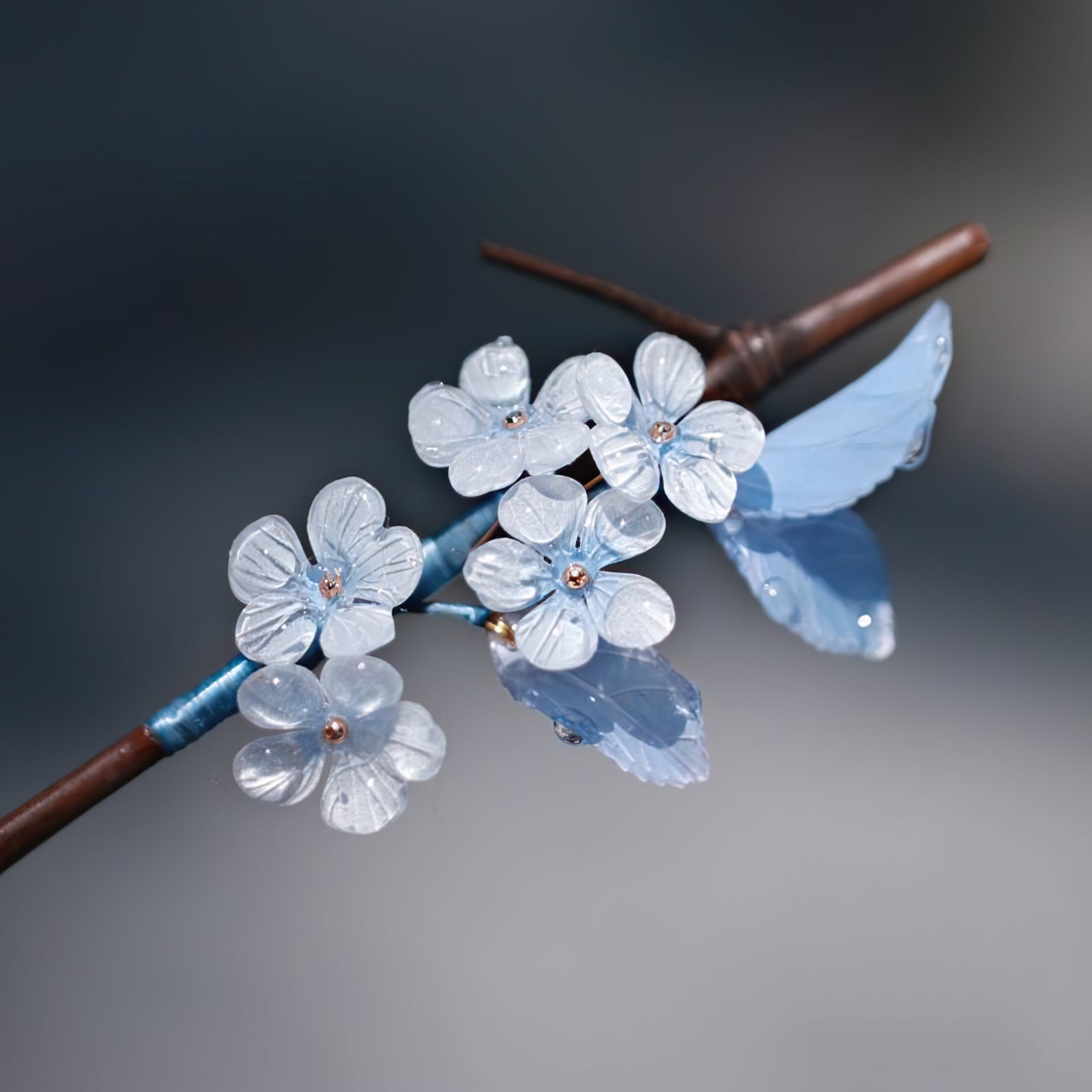 Three-quarter angle of accessory resting on pale fabric background, blue detail visible