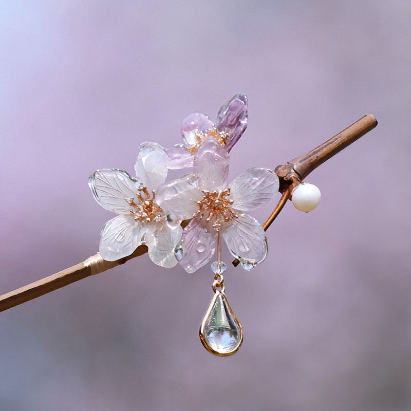 Slender wooden stick with pale floral ornament tucked into a soft bun