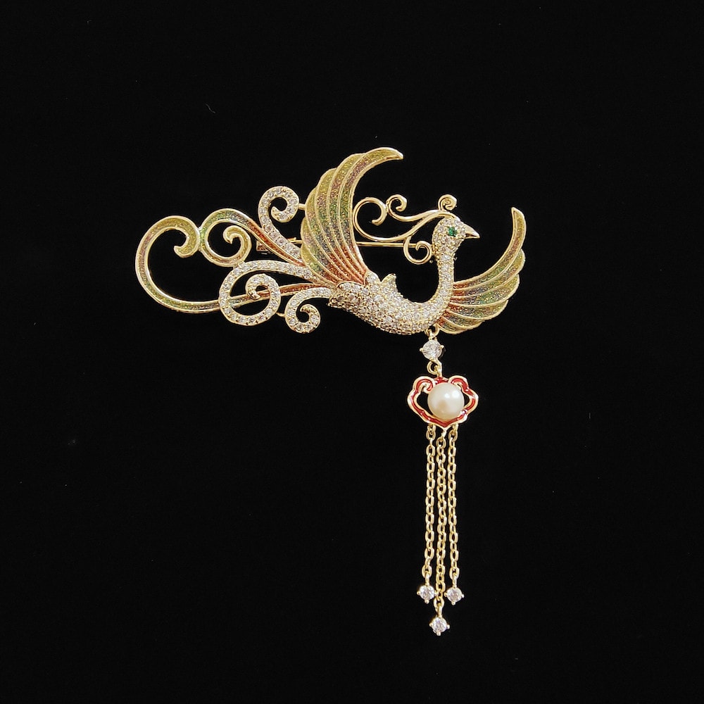 Gold-toned butterfly with creamy pearl tassel pinned to black coat lapel
