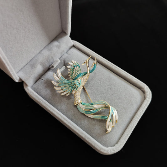 Gold-edged phoenix brooch with red and blue enamel, pinned on navy coat lapel