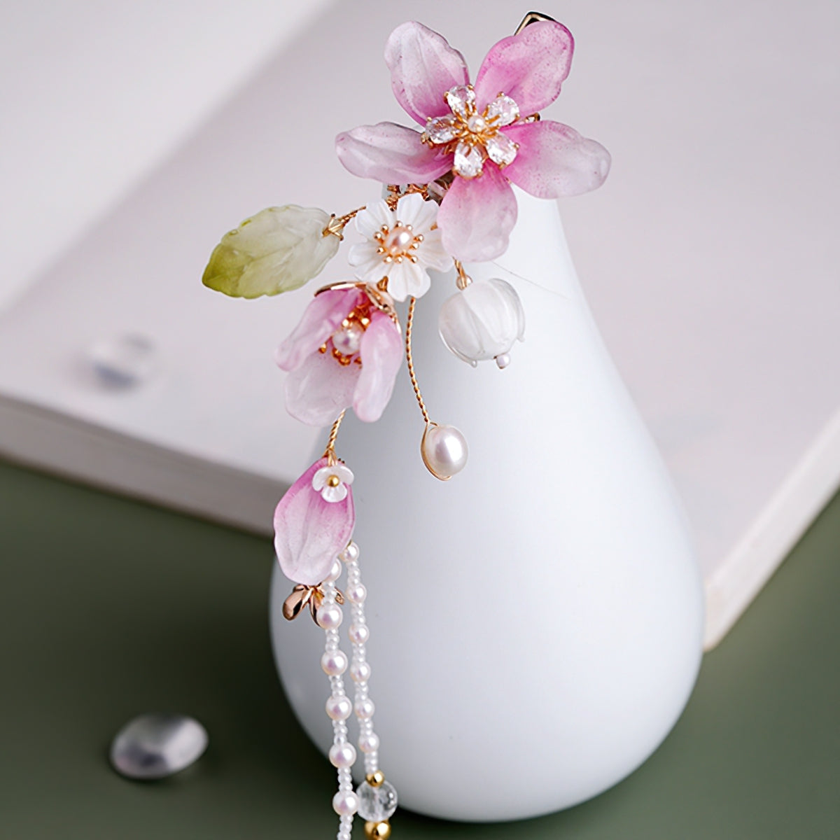 Delicate peach blossom clip with layered petals pinned above a low bun