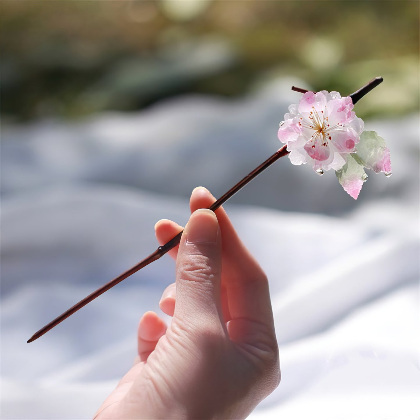 Side view of curved floral hair stick resting through a low twisted bun